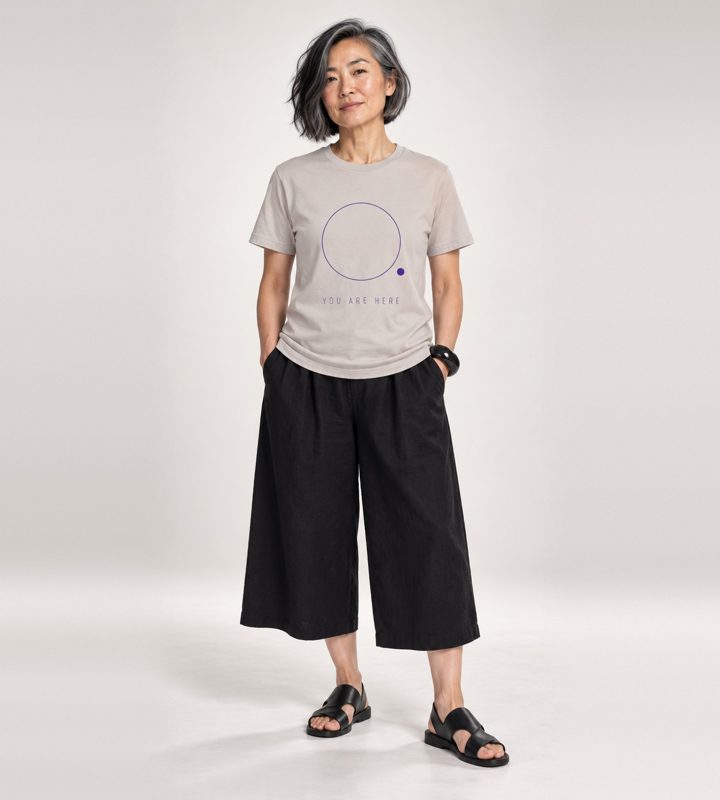A woman in a grey YOU ARE HERE tee